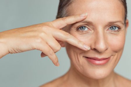 Portrait,Of,Smiling,Senior,Woman,With,Perfect,Skin,Showing,Victory